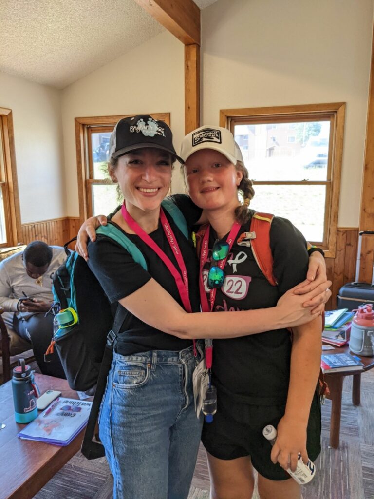 Alexa and Maddy hug, smiling.