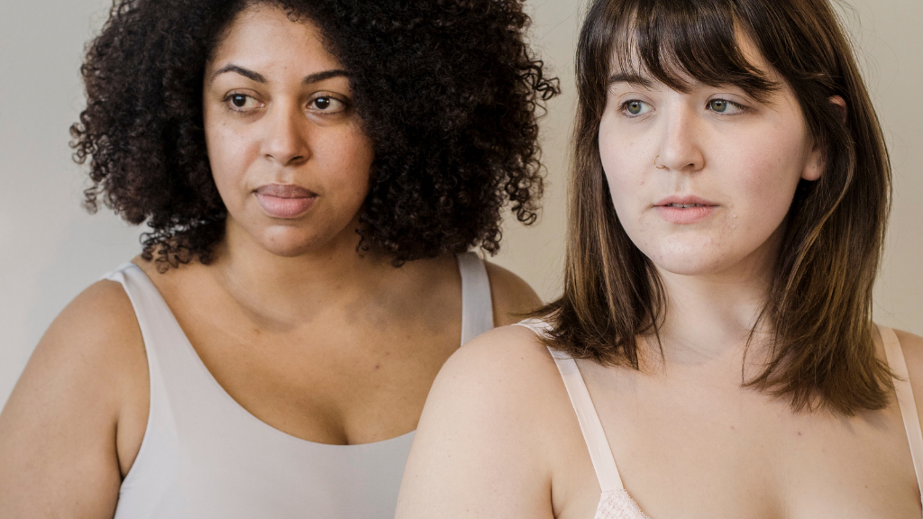 An image depicting two women in tank tops demonstrating body positivity