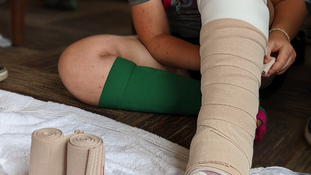 Child wrapping bandages on lower extremity