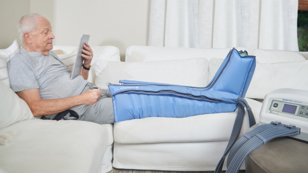 Image of man relaxing on couch using Lympha Press compression therapy device.